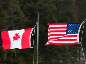 This file photo taken on March 1, 2017, shows the Canadian and American flags seen at the U.S.-Canada border in Pittsburg, N.H.