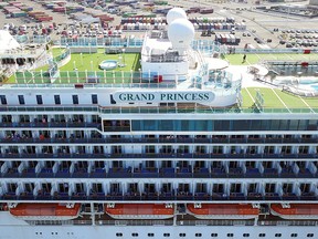 Passengers look out as the Grand Princess cruise ship docks at the Port of Oakland in Oakland, Calif., on March 9, 2020.