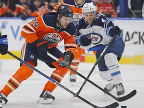 Edmonton Oilers forward Leon Draisaitl (29) carries the puck past Winnipeg Jets defensemen Neal Pionk (4) during the first period at Rogers Place on Saturday.