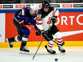 In this April 6, 2019, file photo, Megan Keller of USA, left, and Blayre Turnbull of Canada in action during the 2019 IIHF Women's World Championships preliminary match between USA and Canada in Espoo, Finland.