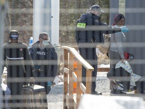 Asylum seekers cross the border from New York into Canada at Roxham Road Wednesday, March 18, 2020 in Hemmingford, Quebec. THE CANADIAN PRESS/Ryan Remiorz