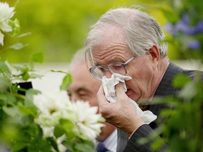 A man covers his face while sneezing in London. (JIM WATSON/AFP/Getty Images)