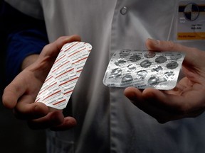 In this file photo taken on February 26, 2020 a medical staffer shows packets of Nivaquine, tablets containing chloroquine, and Plaqueril, tablets containing hydroxychloroquine, drugs that has shown signs of effectiveness against coronavirus. (GERARD JULIEN/AFP via Getty Images)