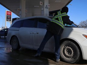 An attendant cleans the windshield while a customer fuels up at Co-op Gas Bar on Pembina Highway at Taylor Avenue in Winnipeg on Mon., March 16, 2020. Kevin King/Winnipeg Sun/Postmedia Network