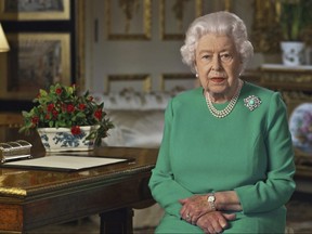 In this image taken from video and made available by Buckingham Palace, Queen Elizabeth II addresses the nation and the Commonwealth from Windsor Castle, Windsor, England, Sunday April 5, 2020. (Buckingham Palace via AP)