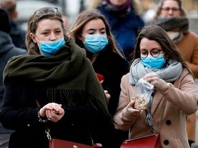 People wearing protective face masks are pictured near to Buckingham Palace in central London on March 15, 2020. (Photo by Tolga AKMEN / AFP) (Photo by TOLGA AKMEN/AFP via Getty Images)