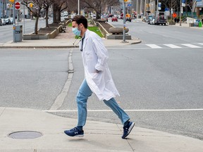 A health-care worker runs across University Ave. from Mount Sinai Hospital to Toronto General Hospital as the number of the coronavirus disease (COVID-19) cases continues to grow in Toronto, April 17, 2020.