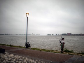 A man plays the bag pipes at dawn at the Mississippi river on Easter Sunday in New Orleans amid the outbreak of the COVID-19, April 12, 2020.