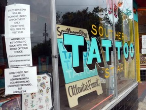 A sign on the window of Southern Star Tattoo informs customers that tattoos are by appointment only in Little Five Points in Atlanta, Georgia on Thursday, April 23, 2020.