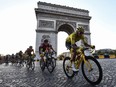 In this file photo taken on July 28, 2019 Colombia's Egan Bernal and cyclists ride down the Champs Elysees aenue next to the Arc de Triomphe in Paris.