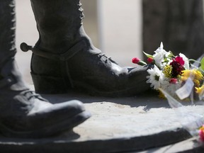 Flowers lay at the feet of the Slain Peace Officer monument at D Division in Winnipeg on Tuesday out of respect for the victims of the Nova Scotia mass killing.