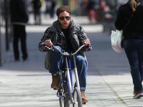 A person riding a bicycle through downtown Winnipeg on Friday.