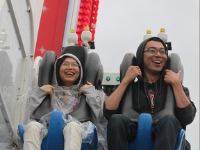 Two Manitobans enjoy the ride aboard the Mach 3, on the final day of the 2013 Red River Exhibition.