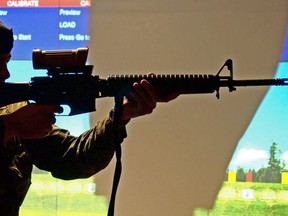A Canadian soldier aims a C7 rifle -- one of weapons on the governments list of banned guns -- at an armory in Edmonton on Dec. 26, 2012.