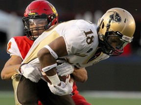 Manitoba Bisons receiver Macho Bockru (right) is tackled by Calgary Dinos DB Deane Leonard at McMahon Stadium on Sept. 6, 2019