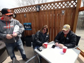 Owner David Thompson (left) speaks with customers Mark Sealey and Jan Mikowas on the patio at Smitty's restaurant on Pembina Highway in Winnipeg over the lunch hour on Monday, May 4, 2020.