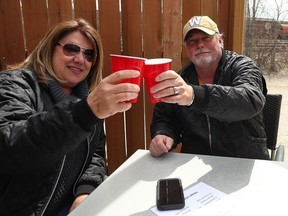 Jan Mikawos and Mark Sealey toast on the patio at Smitty's restaurant on Pembina Highway in Winnipeg over the lunch hour on Monday.