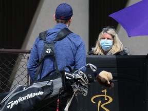 A golfer is screened at the entrance to Rossmere Golf and Country Club on Watt Street in Winnipeg on Monday.