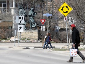 Pedestrians cross at a traffic calming circle on Waterfront Drive at Bannatyne Avenue in Winnipeg earlier this year.