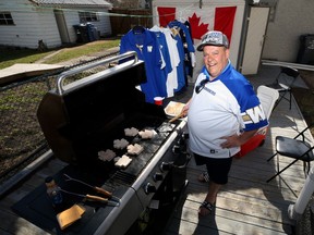Daryl Budnick, who is planning a virtual tailgate party on the day the CFL season was to open, gets into the spirit of things at his home in Winnipeg on Tues., May 12, 2020. Kevin King/Winnipeg Sun/Postmedia Network