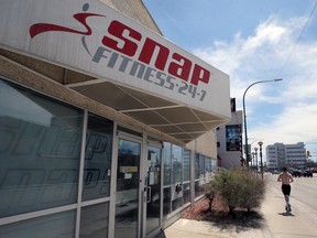 A jogger passes Snap Fitness on Osborne Street in Winnipeg on Monday.