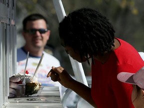 A woman checks on her order at the Bridge Drive-In on Jubilee Avenue in Winnipeg on Mon., May 18, 2020.