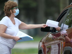 A motorist accepts paperwork at the Covid-19 testing station on Main Street, in Winnipeg.  Friday, May 22/2020.