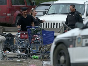 A police officer at a homeless camp near Henry Avenue and Main Street in Winnipeg on Friday.