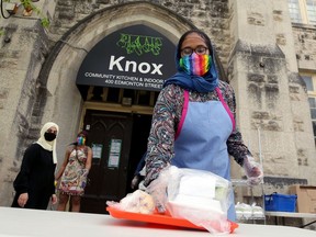 A volunteer places a meal on a table for pickup during a special Eid lunch service at Knox United Church in Winnipeg on Sun., May 24, 2020.