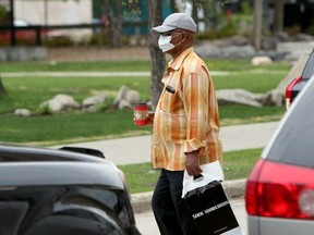 A man wearing a mask walks on Edmonton Street in Winnipeg on Sunday.