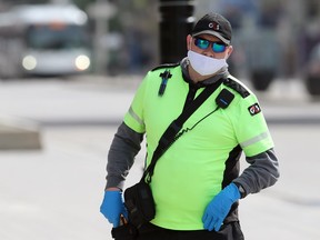 A security guard walks on Portage Avenue in Winnipeg on Mon., May 25, 2020.
