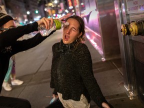 A protester washes the eyes of fellow demonstrator Maire Kelly, 22, who said she was pepper sprayed by New York City police during a march over the death of George Floyd on June 1, 2020 in New York City.