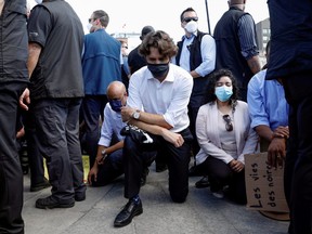 Prime Minister Justin Trudeau wears a mask as he takes a knee during a rally against the death in Minneapolis police custody of George Floyd, on Parliament Hill, in Ottawa, June 5, 2020.