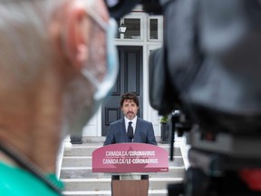 A camera person wears a mask as Canadian Prime Minister Justin Trudeau speaks during his daily coronavirus briefing at Rideau Cottage in Ottawa, June 25, 2020.