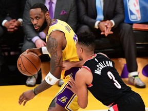 In this file photo LeBron James of the Lakers looks to pass under pressure from C.J. McCollum of the Trailblazers during NBA action in Los Angeles, Jan. 31, 2020.