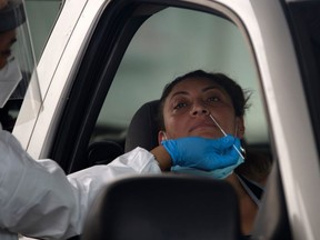 A healthcare worker administers a COVID-19 test at United Memorial Medical Center testing site in Houston, Texas, Thursday, June 25, 2020.