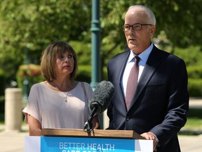 Anne Oake listens to husband Scott speak during a press conference on the south side of the Manitoba Legislative Building grounds where the province announced a $3.5-million grant for the Bruce Oake Recovery Centre in Winnipeg on Monday, June 1, 2020.