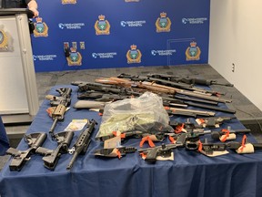Winnipeg Police show off a cache of seized firearms at a press conference at Winnipeg Police headquarters on Tuesday. Winnipeg Police announced a large seizure of firearms in two separate investigations.