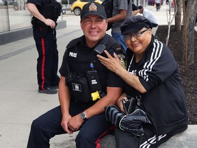 An indigenous woman poses with a patrol officer on Portage Avenue in Winnipeg on Mon., June 8, 2020. Kevin King/Winnipeg Sun/Postmedia Network