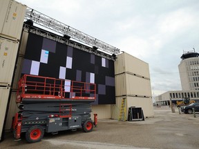 Workers install a large LED movie screen for a drive-in theatre in the economy parking lot at the Winnipeg Richardson International Airport, earlier this month. The RWB and WSO are teaming up for 30-minute performances at the pop-up drive-in movie theatre before screenings of Shall We Dance? this weekend.