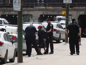 A woman is placed into a police cruiser following an incident that saw a number of cars and an ambulance called to Main Street between Sutherland and Jarvis avenues in Winnipeg on Sunday.