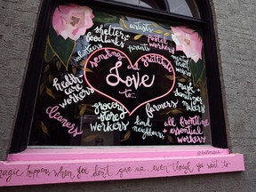 A sign in the window of a store on McDermot Avenue offers support to those engaged in the fight against COVID-19 in Winnipeg on Tuesday.
