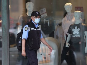 A Winnipeg Transit employee walks past a department store on Portage Avenue.