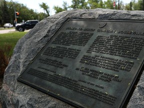 A plaque marking the opening of Bishop Grandin Boulevard in Winnipeg sits on the thoroughfare along River Road.