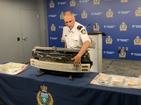 Insp. Max Waddell of the Winnipeg Police Service Guns and Gangs Unit demonstrates the operation of a sophisticated "concealment trap" located at the rear of a 2018 Nissan Murano at a press conference on Friday. The vehicle was seized during an arrest last Friday of a 31-year-old man from Vancouver as part of an interprovincial illicit drug crime network involving the transportation of multiple kilograms of cocaine from Vancouver through Calgary and Regina with the final destination being Winnipeg.
