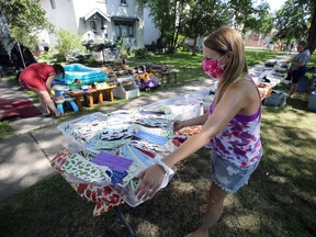 Tammy Chaplin (centre) and her crew had thousands of masks available during a block-long yard sale on Warsaw Avenue in Winnipeg on Sunday.