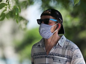 A man wearing a mask runs on Corydon Avenue in Winnipeg on Monday, June 29, 2020.