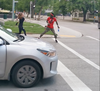 A pair of people who participated in a protest on July 4 and were walking east on Broadway were attacked by a woman with a hockey stick, as shown in this screengrab from a Facebook video.