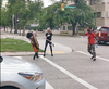 A pair of people who participated in a protest on July 4 and were walking east on Broadway were attacked by a woman with a hockey stick, as shown in this screengrab from a Facebook video.