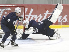 Winnipeg Jets goaltender Connor Hellebuyck stops a shot from Nikolaj Ehlers during practice.